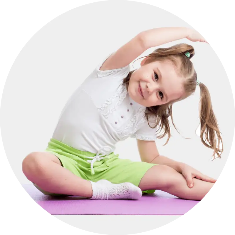 Fit for Kids – Bewegungsfreude von klein auf Lächelndes Mädchen in Sportkleidung macht spielerische Dehnübung auf Matte.